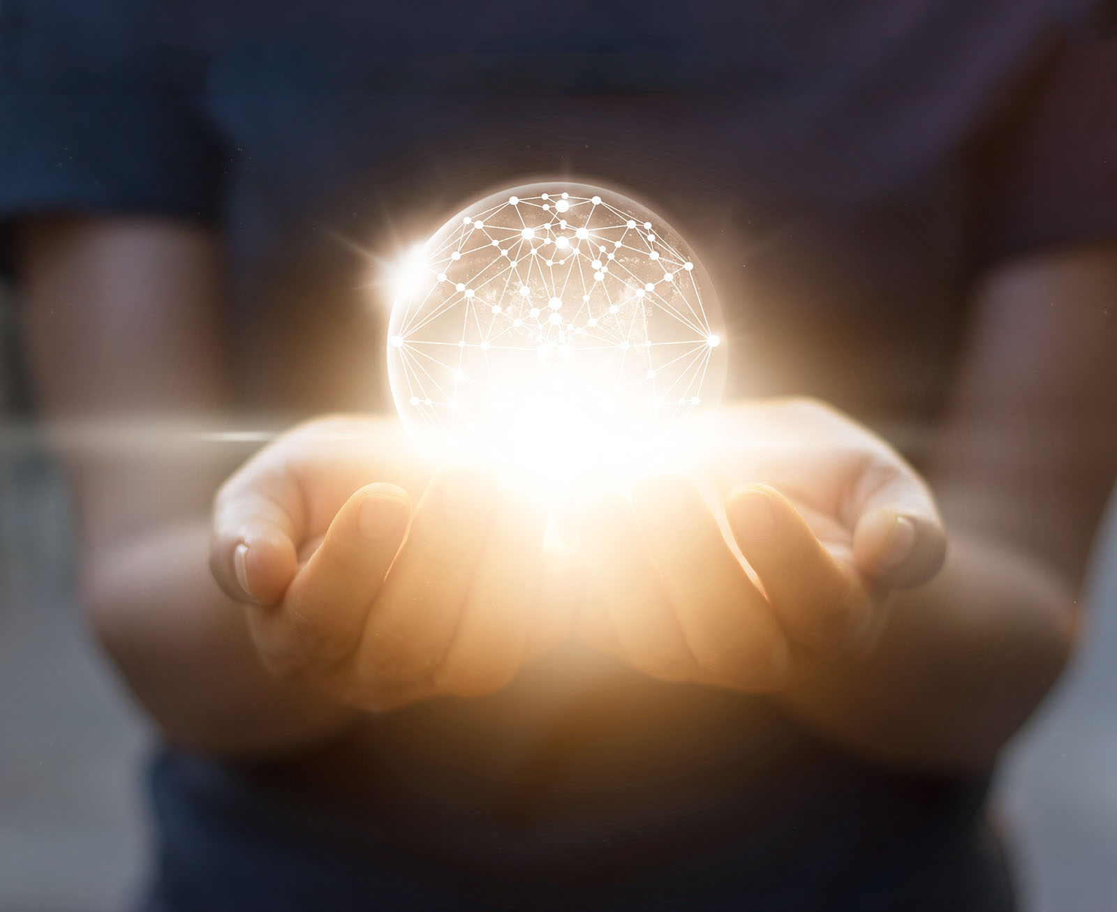 Hands holding a glowing sphere of interconnected light
